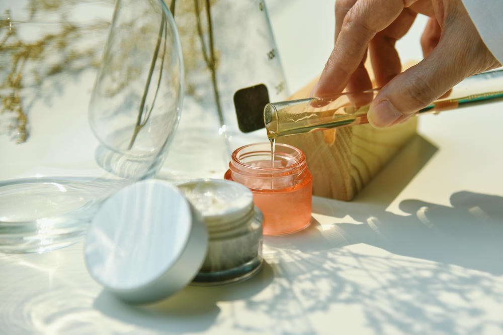 angel liquid. Nhà khoa học trộn các sản phẩm làm đẹp chăm sóc da tự nhiên Chiết xuất thực vật hữu cơ và dụng cụ thủy tinh phòng thí nghiệm khoa học Nhãn trắng trên hộp đựng mỹ phẩm cho thiết kế nhãn hiệu