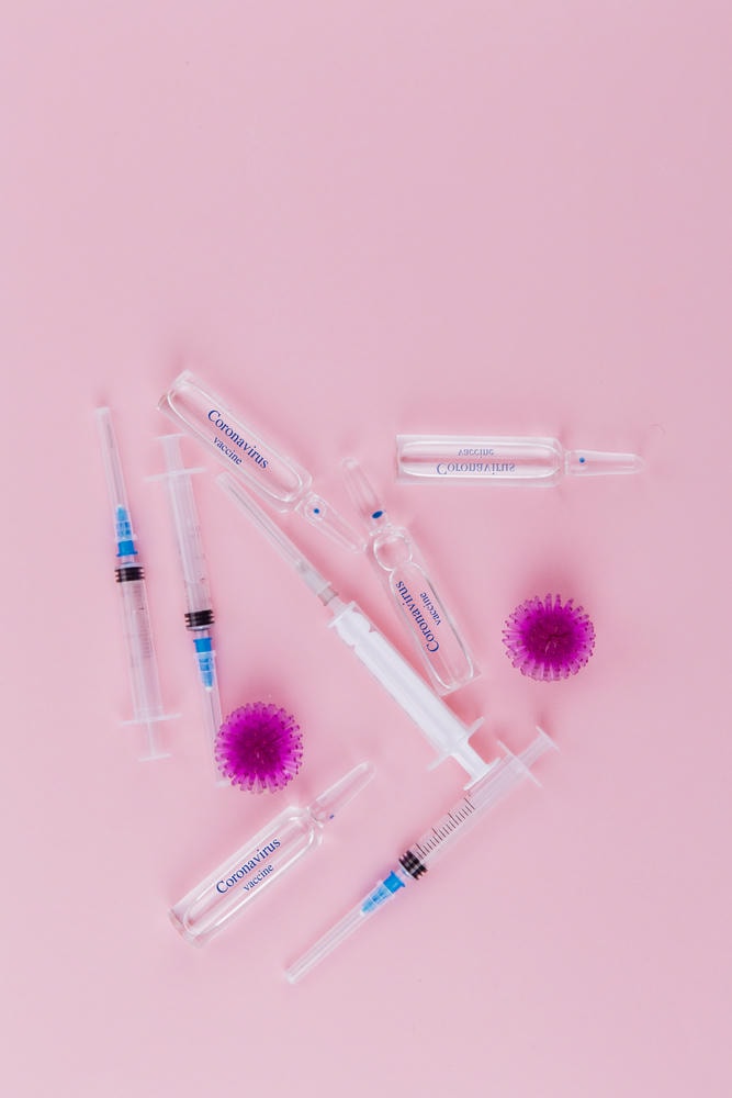 botulinum là gì. Virus đỏ, ống tiêm và ống thuốc với thuốc trên nền hồng.