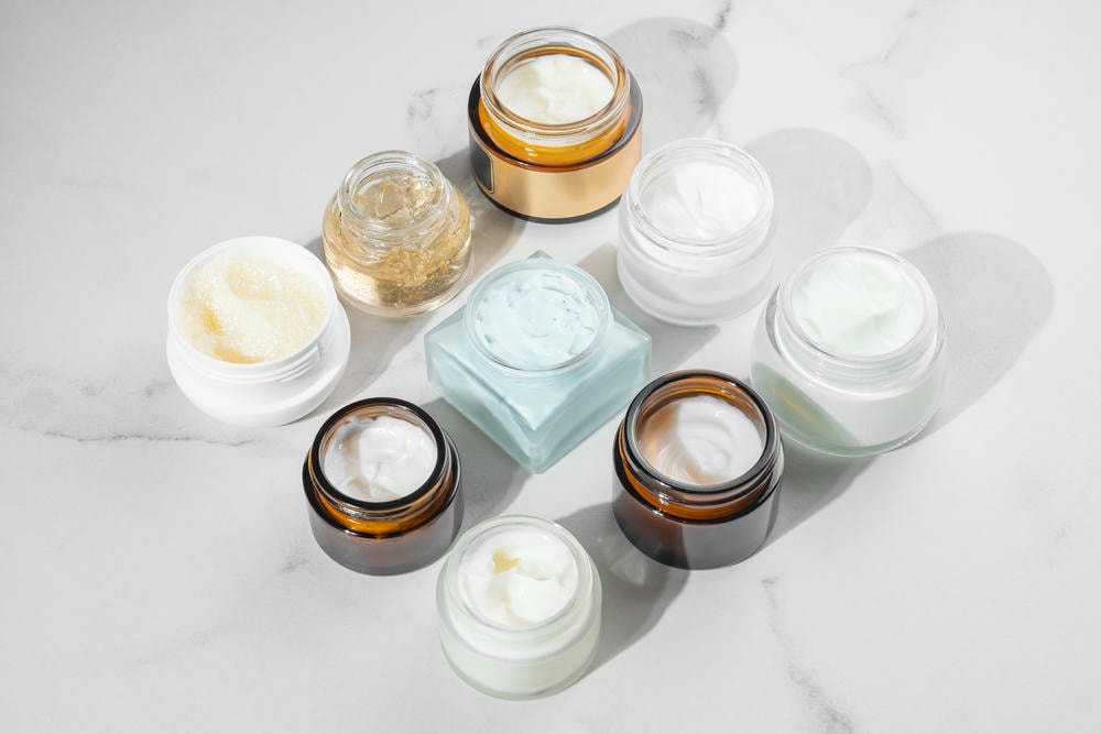 các loại kem. Bao bì mỹ phẩm Bộ lọ mỹ phẩm khác nhau đựng kem dưỡng da mặt, mặt nạ, son dưỡng trên nền đá cẩm thạch màu be Bao bì trống Khái niệm sản phẩm spa làm đẹp Mockup làm đẹp