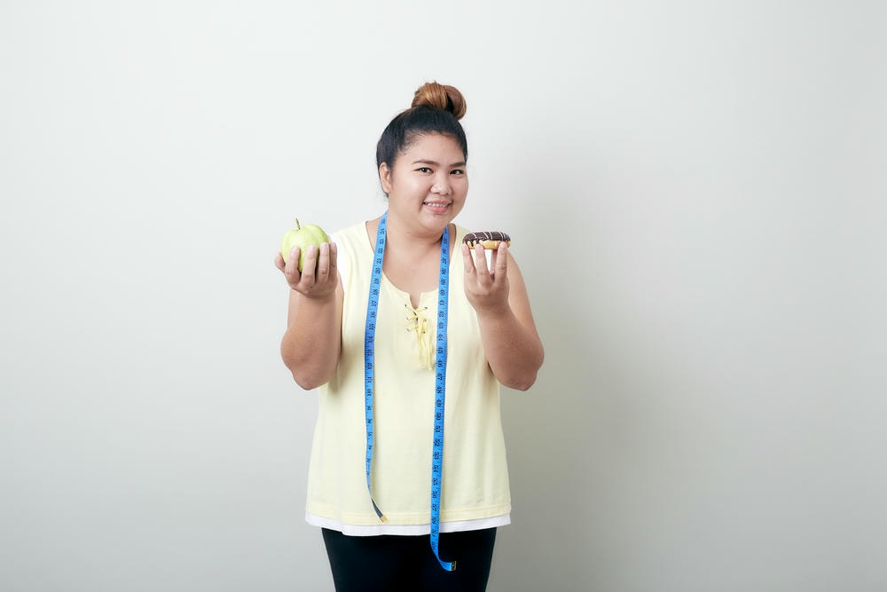 cách giảm cân nhanh nhất. Chân dung người phụ nữ trẻ tươi cười đứng trên nền trắng