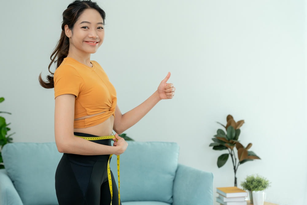 cách giảm cân nhanh nhất. Ăn kiêng và giảm cân. Cơ thể nữ giới thon thả sử dụng thước dây. Người phụ nữ mặc quần áo tập thể dục đạt được mục tiêu giảm cân để có một cuộc sống khỏe mạnh, ám ảnh về sự gầy gò, eo thon, chuyên gia dinh dưỡng