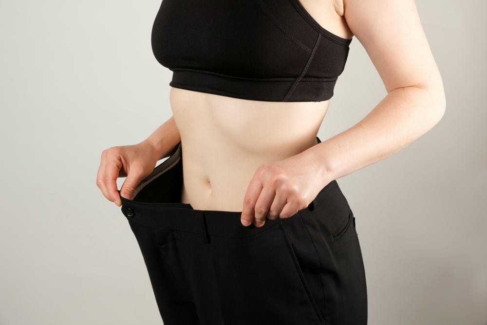 cách làm bụng nhỏ sau sinh tại nhà. Một người phụ nữ mặc chiếc quần rộng sau khi giảm cân
