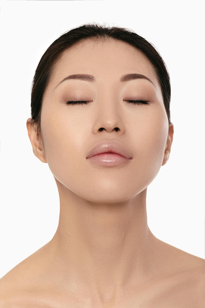cằm tròn. Người phụ nữ châu Á trẻ trên nền trắng