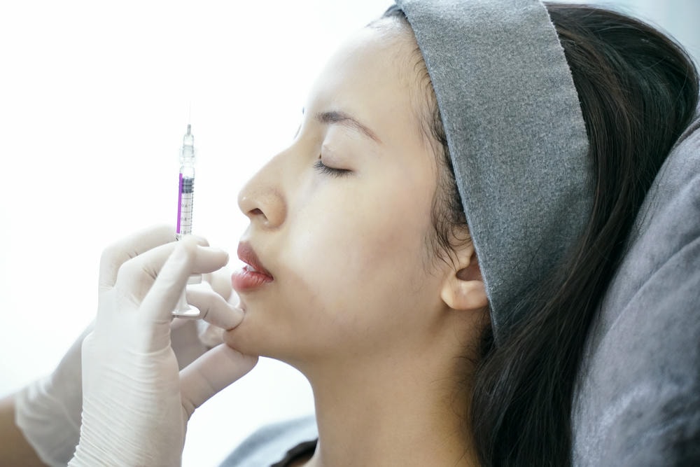 filler hàn quốc. Thủ thuật trẻ hóa bằng tiêm trong phòng khám thẩm mỹ. Tiêm vào cằm phụ nữ.
