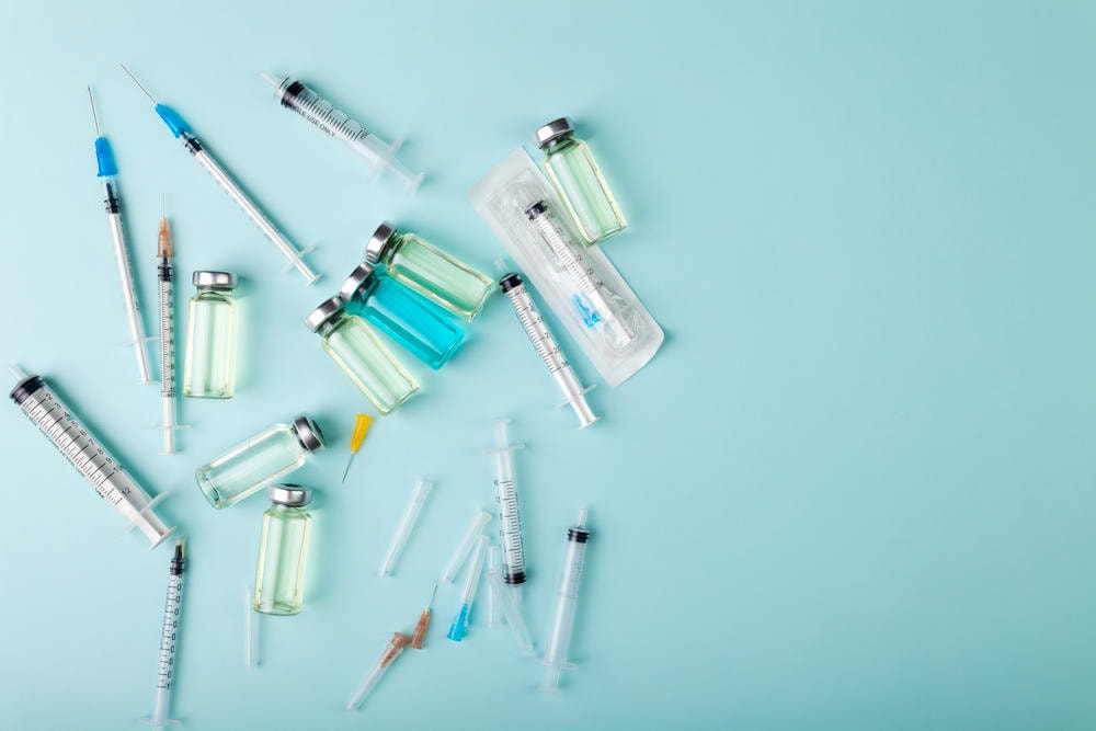 filler juvederm có mấy loại. Ống tiêm vắc-xin thủy tinh, chai lọ và kim tiêm nhìn từ trên xuống