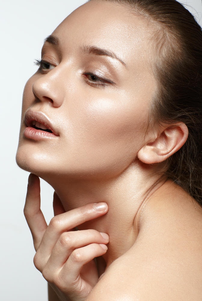 glow skin. Chân dung sắc đẹp. Người phụ nữ xinh đẹp chạm vào khuôn mặt của cô ấy. Làn da tươi tắn hoàn hảo. Cô lập. Vẻ đẹp thuần khiết