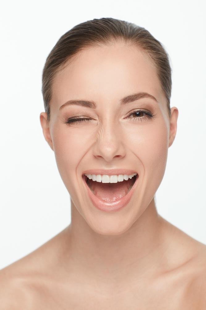 rãnh cười đẹp. Nụ cười chân dung và người phụ nữ nháy mắt để chăm sóc da tán tỉnh hoặc trang điểm làm đẹp được cô lập trên nền studio trắng.
