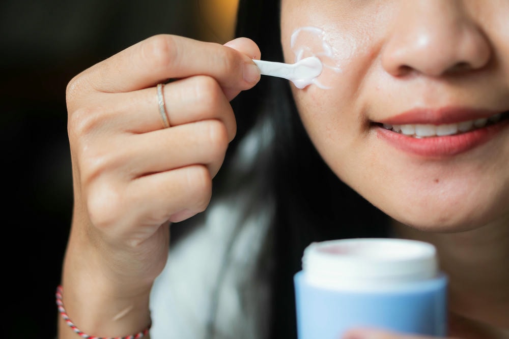thuốc bôi corticoid. Người phụ nữ thoa kem dưỡng da lên da
