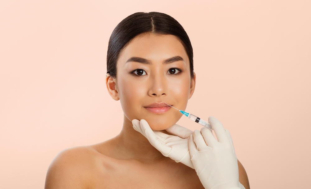 tiêm filler là gì. Người Phụ Nữ Tiêm Môi Trên Nền Hồng