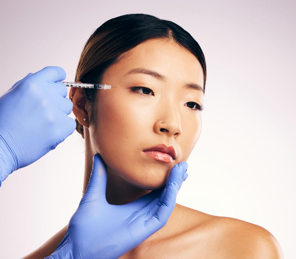 Chuyên gia y khoa đang tiến hành tiêm filler vùng thái dương, kết hợp tiêm filler làm đầy thái dương để khắc phục vùng da lõm, qua đó nhấn mạnh tính chất an toàn của filler thái dương.