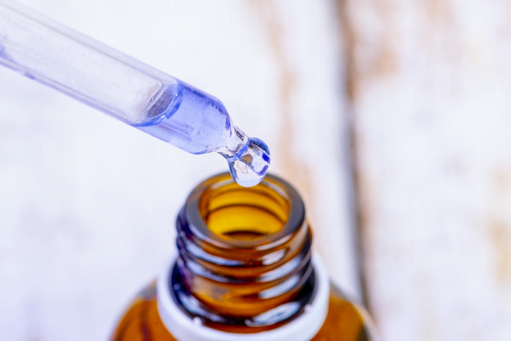 tranexamic. Góc nhìn từ trên cao của đồ uống trong chai thủy tinh trên bàn